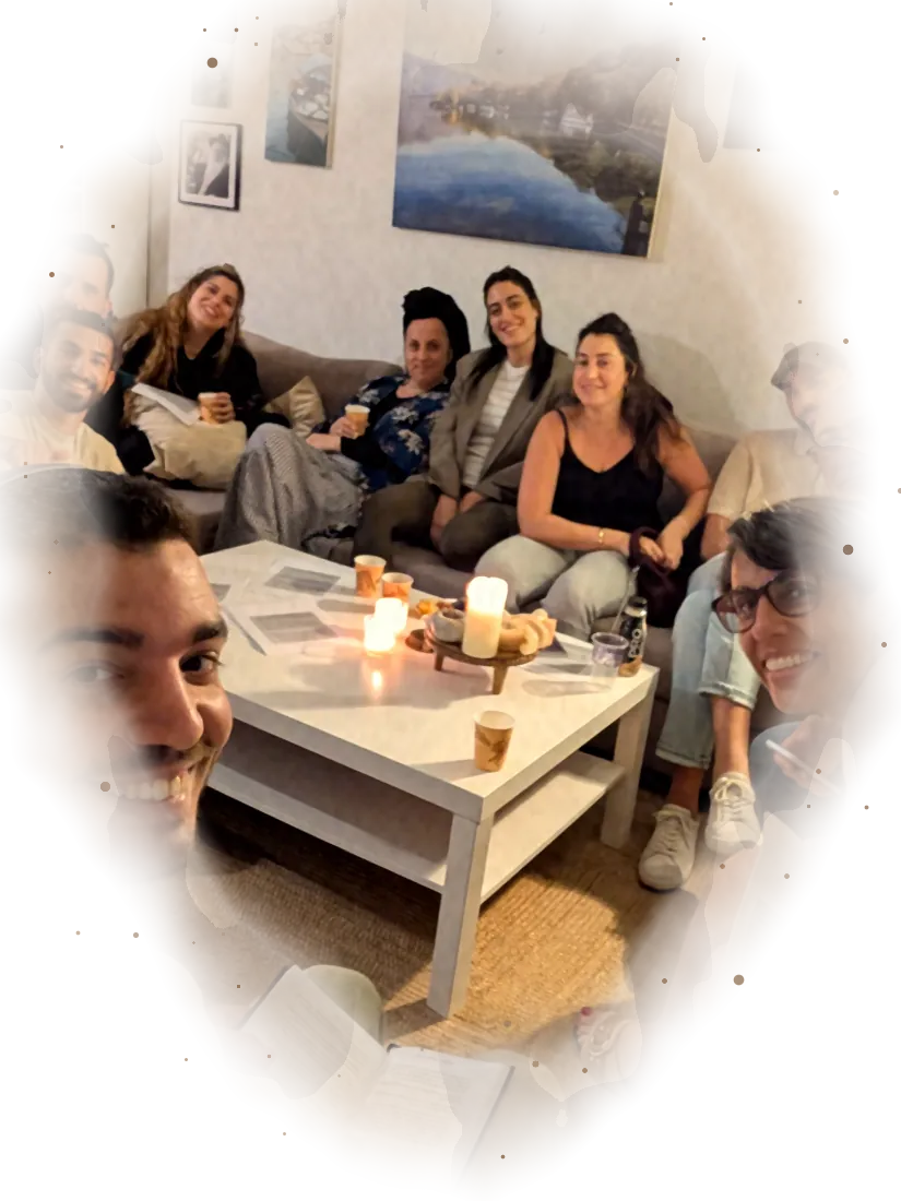 משתתפי הסדנה מחייכים במצלמה בסלון